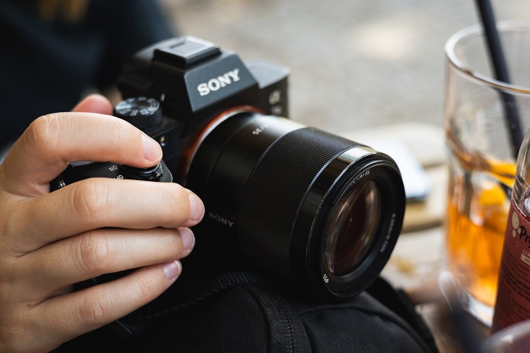 Photographer's hands adjusting a film camera on a wooden table