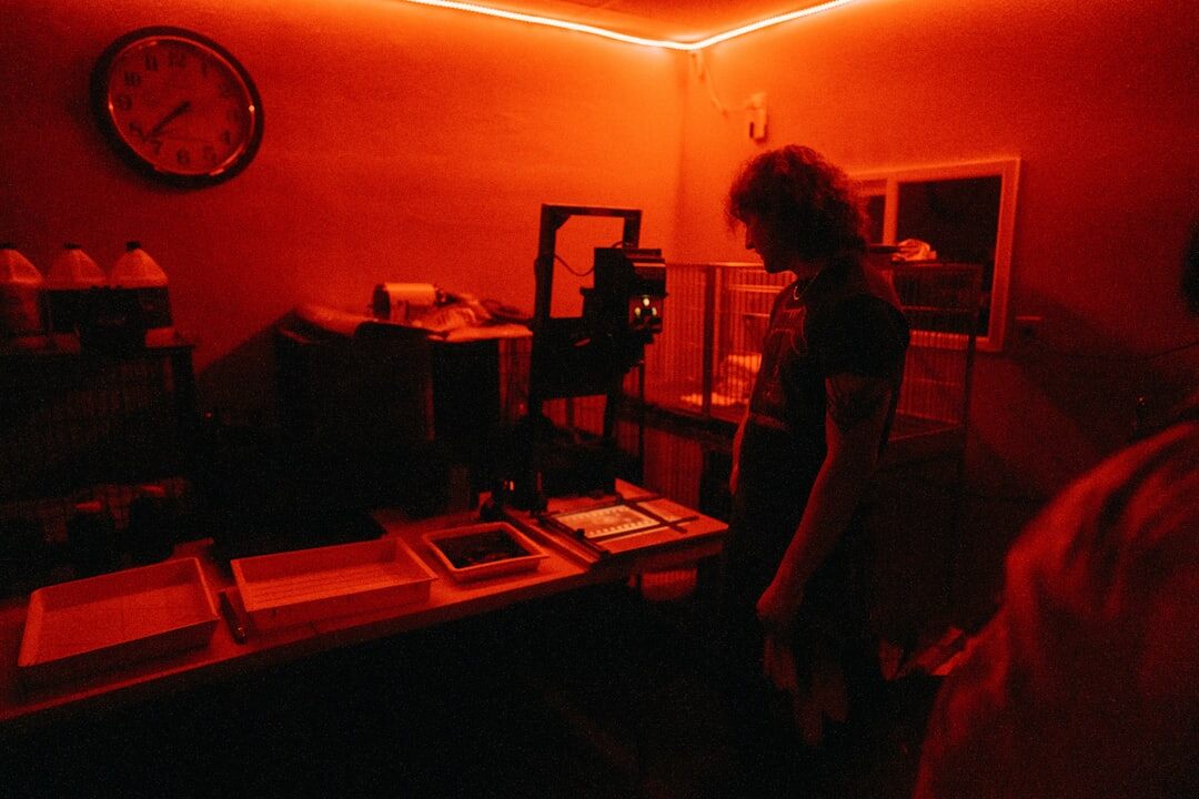 Photographer developing photo prints in a darkroom