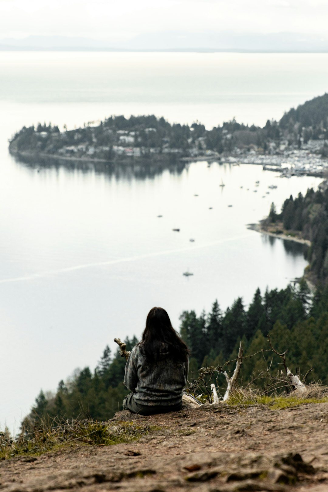 Photographer sitting on a harbor edge editing photo notes