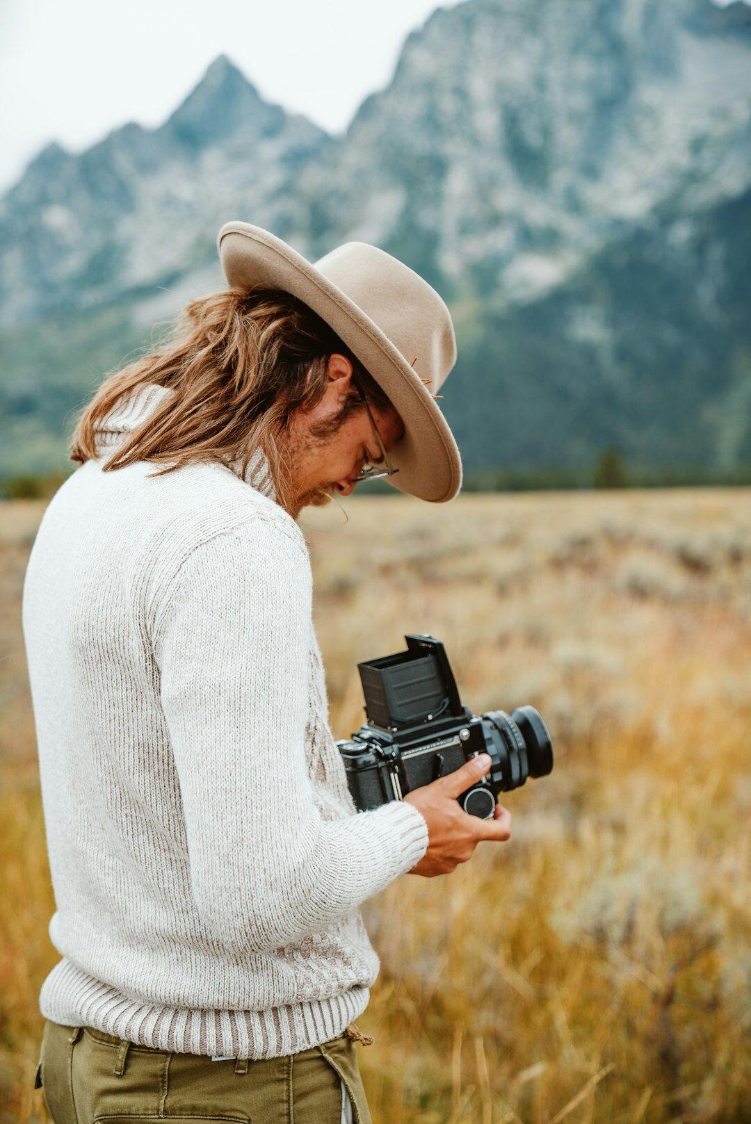 Photographer reviewing photos on a camera screen outdoors